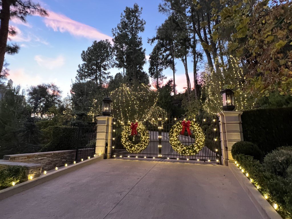 Christmas lighting and holiday wreaths on gates and a driveway in LA, installed by Christmas Brothers professional lighting specialists