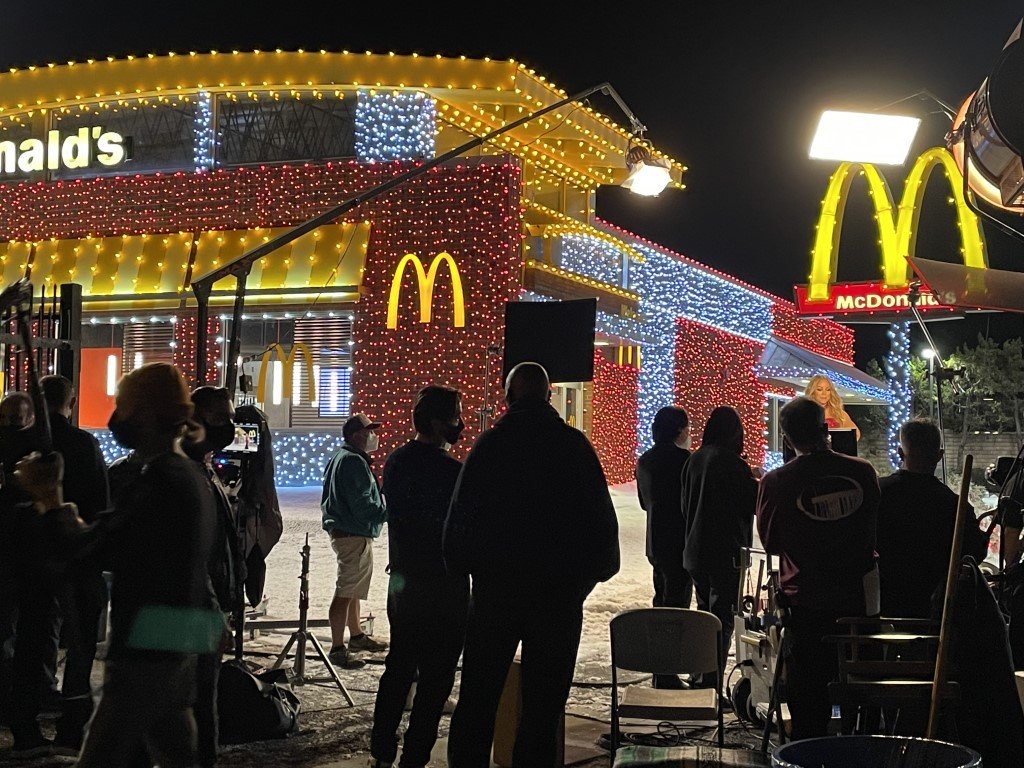 McDonald's image: A production crew decorates a McDonald's building with snow and holiday lighting by Christmas Brothers professional Christmas light installers