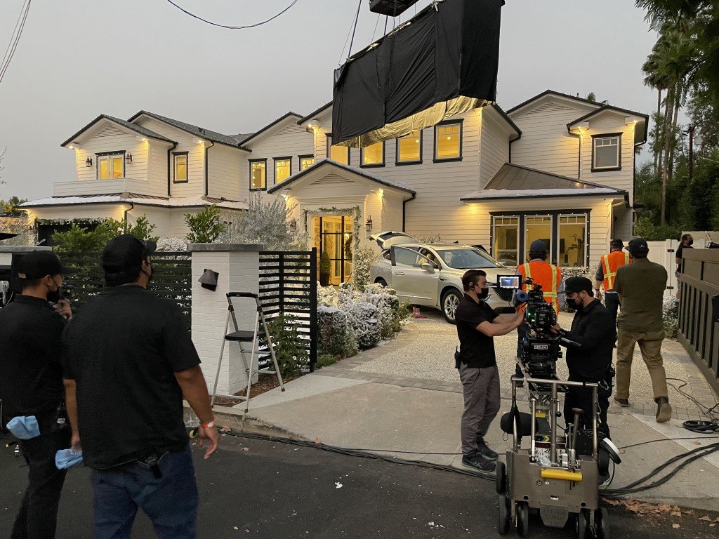 House image with snow: A production crew decorates a California home with fake snow and holiday lighting by Christmas Brothers professional Christmas light installers